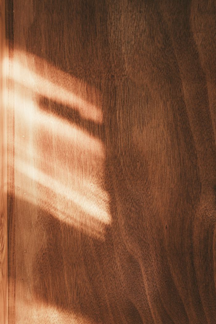 services-04 Soft sunlight streaming through creating patterns on a wooden surface, casting warm, earthy tones.