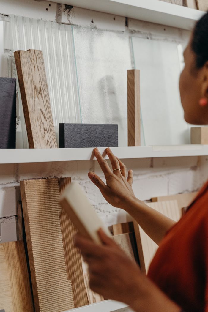 why-choose-us Close-up of woman choosing wood samples for interior design project.